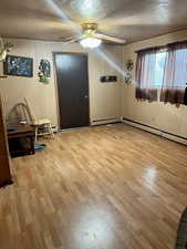 Entrance foyer with a textured ceiling, light wood-style flooring, a ceiling fan, and wooden walls