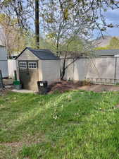 View of home's exterior featuring a storage unit and a shingled roof