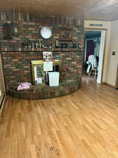 Living area featuring wood finished floors and a baseboard heating unit