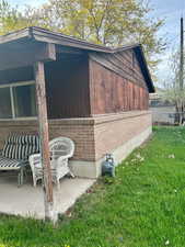 View of side of property featuring brick siding and a patio area