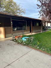 View of front of house featuring brick siding, a patio area, a carport, and concrete driveway