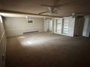 Unfurnished bedroom with a textured ceiling, carpet, and baseboard heating