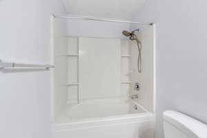 Full bath featuring toilet and washtub / shower combination