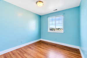 Unfurnished room with light wood-style flooring and baseboards