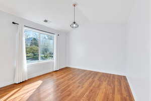 Spare room featuring lofted ceiling and light wood-type flooring