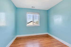 Spare room featuring light wood-type flooring and baseboards