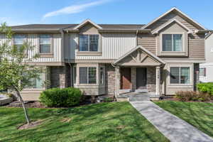 Craftsman inspired home with a front yard and stone siding