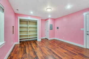 Unfurnished room featuring dark wood finished floors, electric panel, and recessed lighting