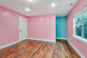 Spare room featuring dark wood finished floors and a textured ceiling