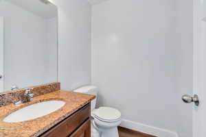Half bath with vanity and dark wood finished floors