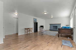 Living area with a fireplace and light wood finished floors