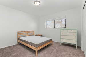 Bedroom featuring carpet floors and baseboards