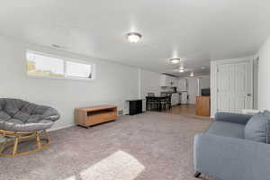 Living area with light carpet and baseboards
