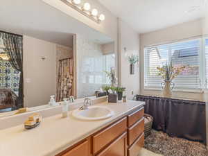 Full bath with a shower with curtain, vanity, and connected bathroom