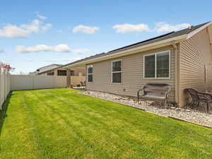 Back of house with a fenced backyard and a patio area
