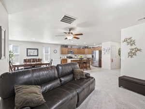 Living area featuring light colored carpet, recessed lighting, and a ceiling fan