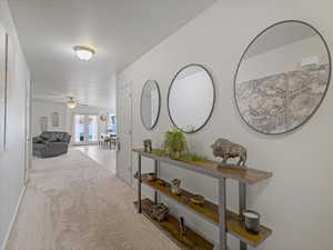 Corridor featuring light carpet and baseboards