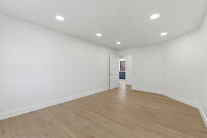 Spare room with light wood finished floors and recessed lighting