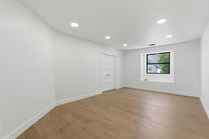 Empty room featuring light wood-style floors and recessed lighting