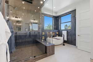 Full bath with a marble finish shower, a freestanding bath, and tile walls