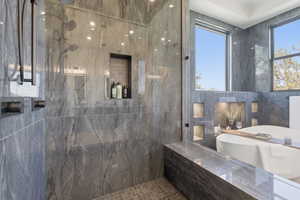 Full bathroom with a marble finish shower and tile walls