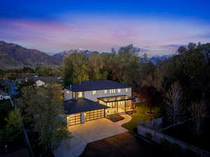 View of front of house with concrete driveway, a patio area, and a mountain view