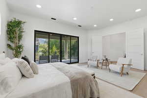 Bedroom with wood finished floors, access to outside, and recessed lighting