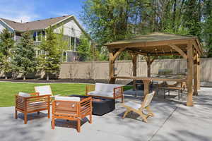 Fenced backyard with a patio area and an outdoor living space with a fire pit