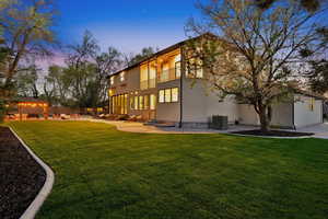 Back of property at dusk with a patio, and a balcony