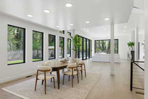 Dining area with recessed lighting and light wood finished floors