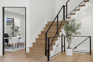Stairs featuring wood finished floors and recessed lighting