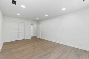 Unfurnished bedroom with light wood finished floors, a closet, and recessed lighting