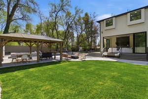 View of yard featuring a patio area, an outdoor living space with a fire pit, and a gazebo