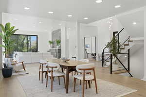 Dining room with light wood finished floors and recessed lighting