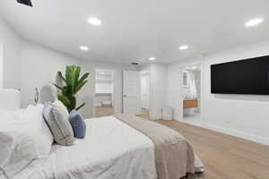 Bedroom with light wood-type flooring, a walk in closet, recessed lighting, and ensuite bathroom