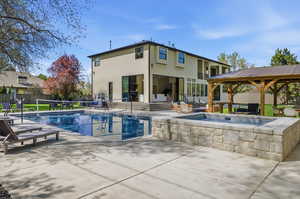View of swimming pool with patio surround and a gazebo