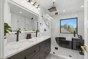 Bathroom featuring double vanity, a freestanding bath, a stall shower, tile walls, and recessed lighting