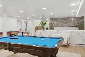 Game room with recessed lighting, an accent wall, billiards, and light wood finished floors