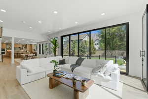 Living area with light wood-style flooring and recessed lighting