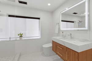 Bathroom with tiled shower and vanity