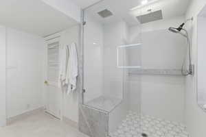 Full bath featuring a shower stall and light tile patterned floors