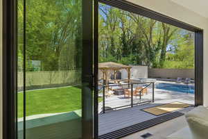 Doorway featuring view of wooded area