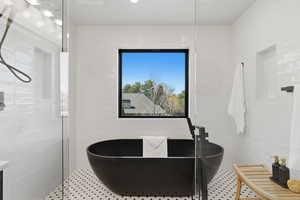 Full bath with a freestanding bath and tile walls