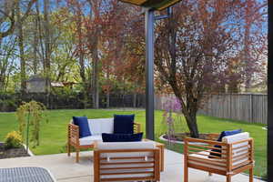 Fenced backyard with outdoor lounge area and a patio