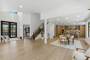 Entrance foyer featuring recessed lighting, light wood-style flooring, and a high ceiling