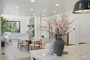 Dining room with light wood finished floors and recessed lighting