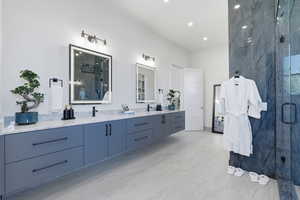 Bathroom featuring a marble finish shower and double vanity