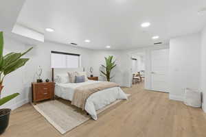 Bedroom with light wood finished floors and recessed lighting