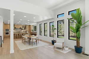 Dining room with light wood-style flooring, recessed lighting, and plenty of natural light