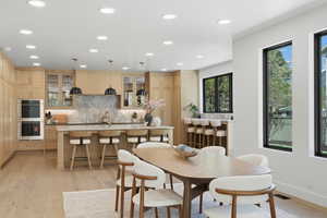 Dining room featuring light wood-style flooring, recessed lighting, and wet bar